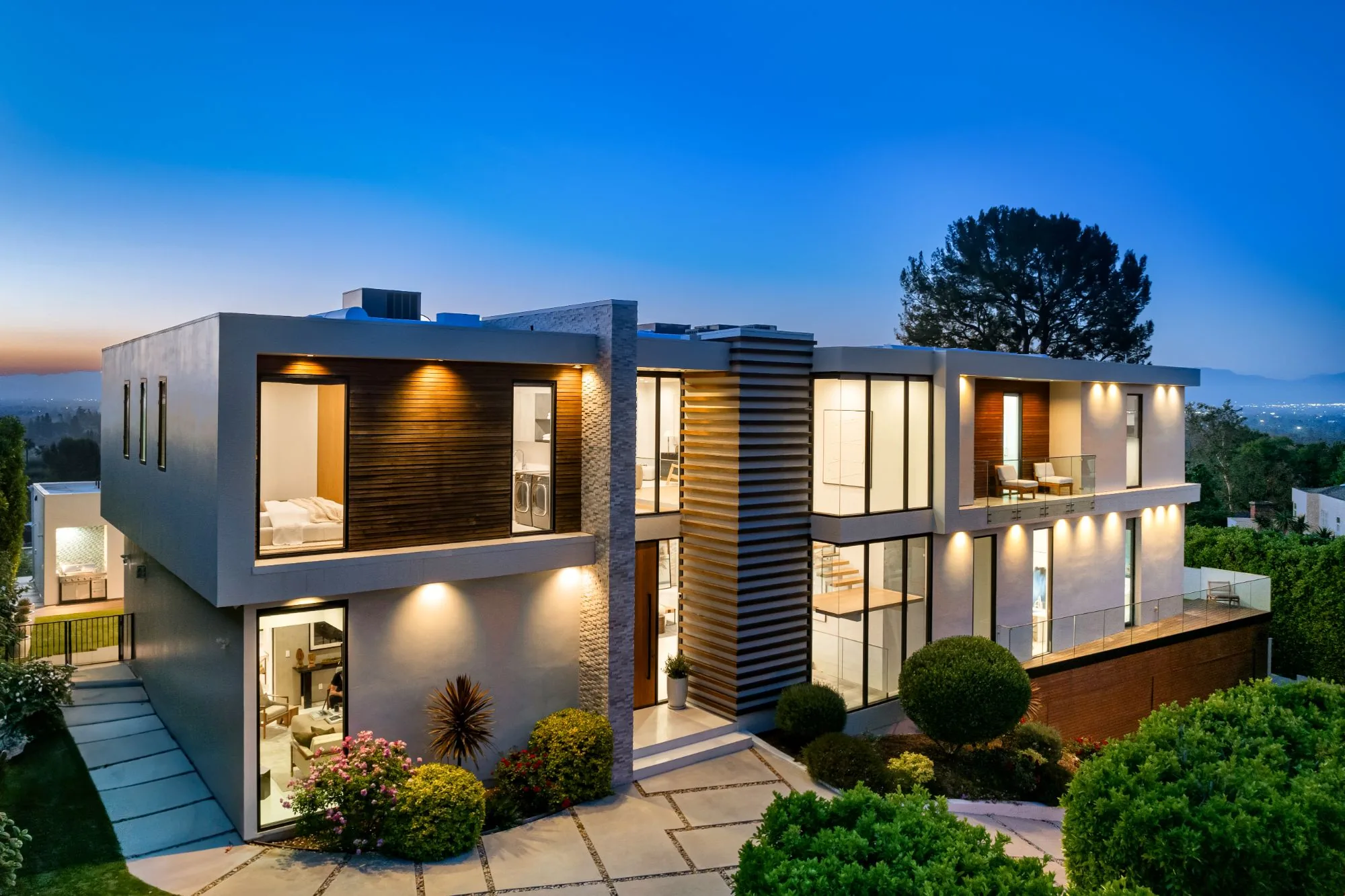 Maison moderne au crépuscule avec un aménagement paysager luxuriant